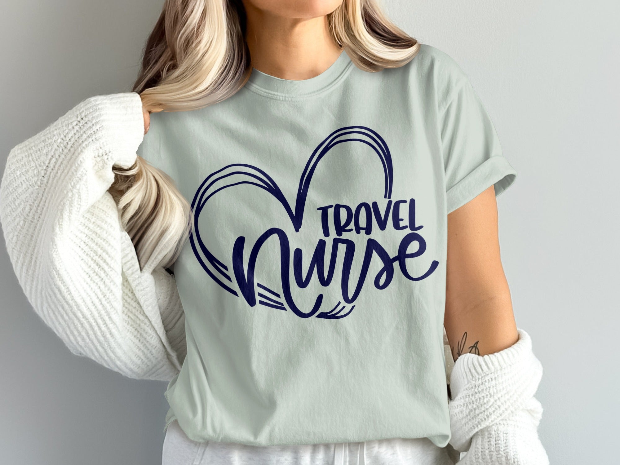 Light blue t-shirt with navy blue heart and "TRAVEL NURSE" text.
