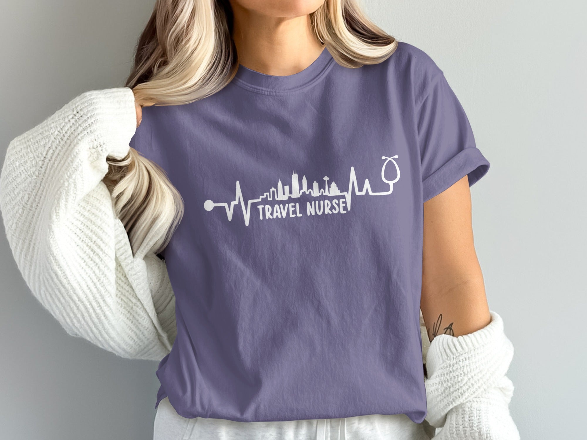 Purple t-shirt with "Travel Nurse" text and skyline heartbeat design.