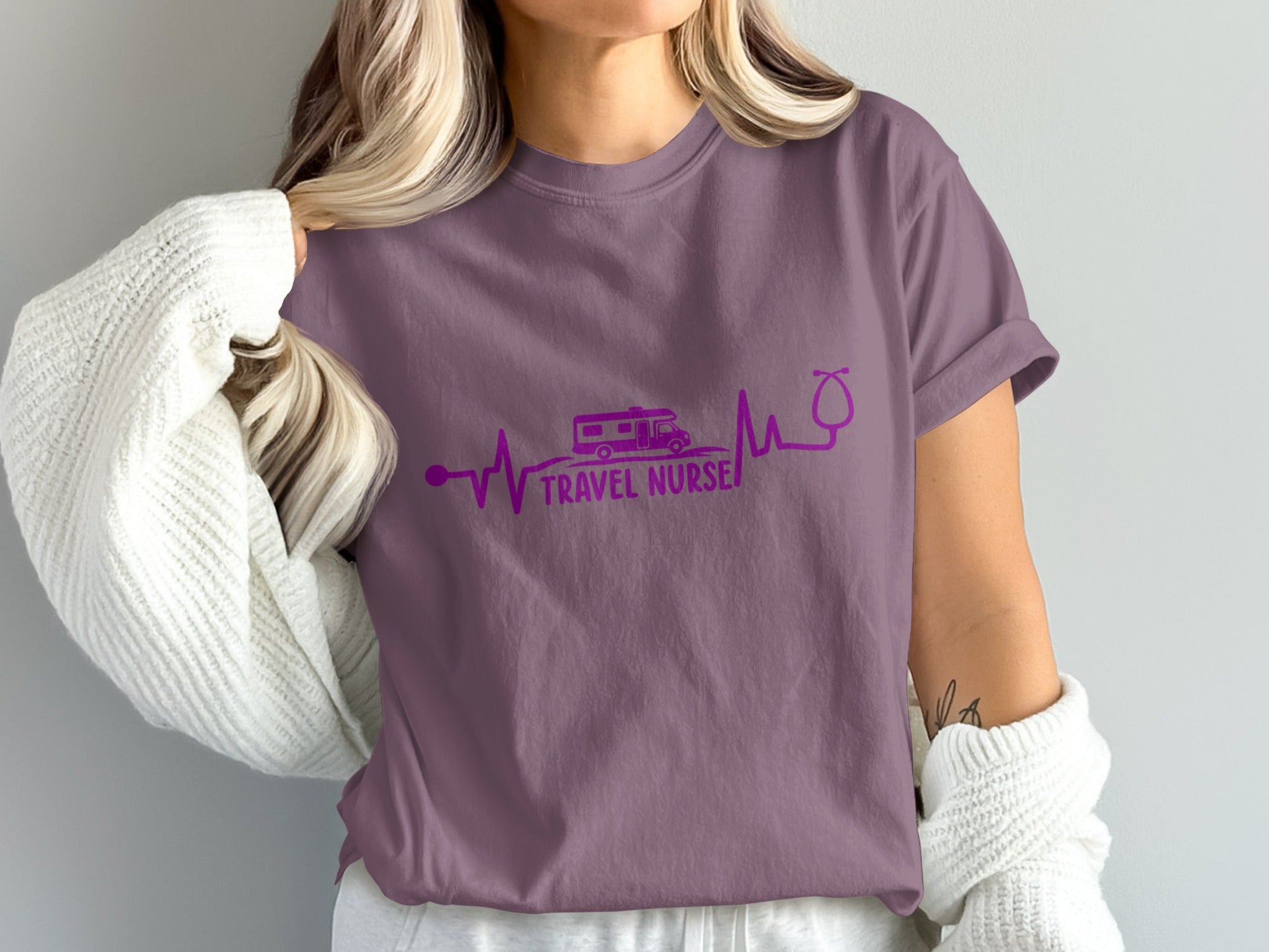 Purple t-shirt with a heartbeat line, RV, and stethoscope forming "TRAVEL NURSE".