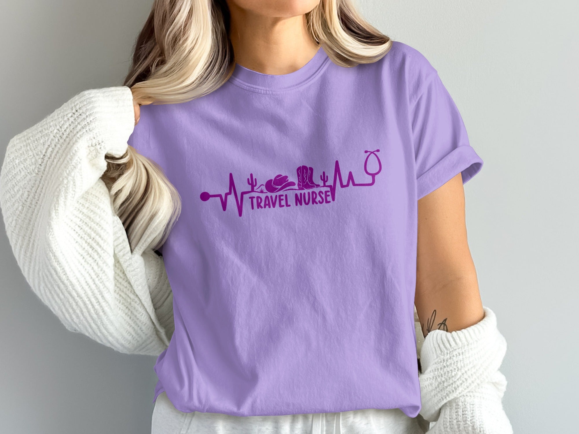 Purple t-shirt with travel nurse heartbeat graphic featuring a stethoscope, cowboy boot, and cactus.