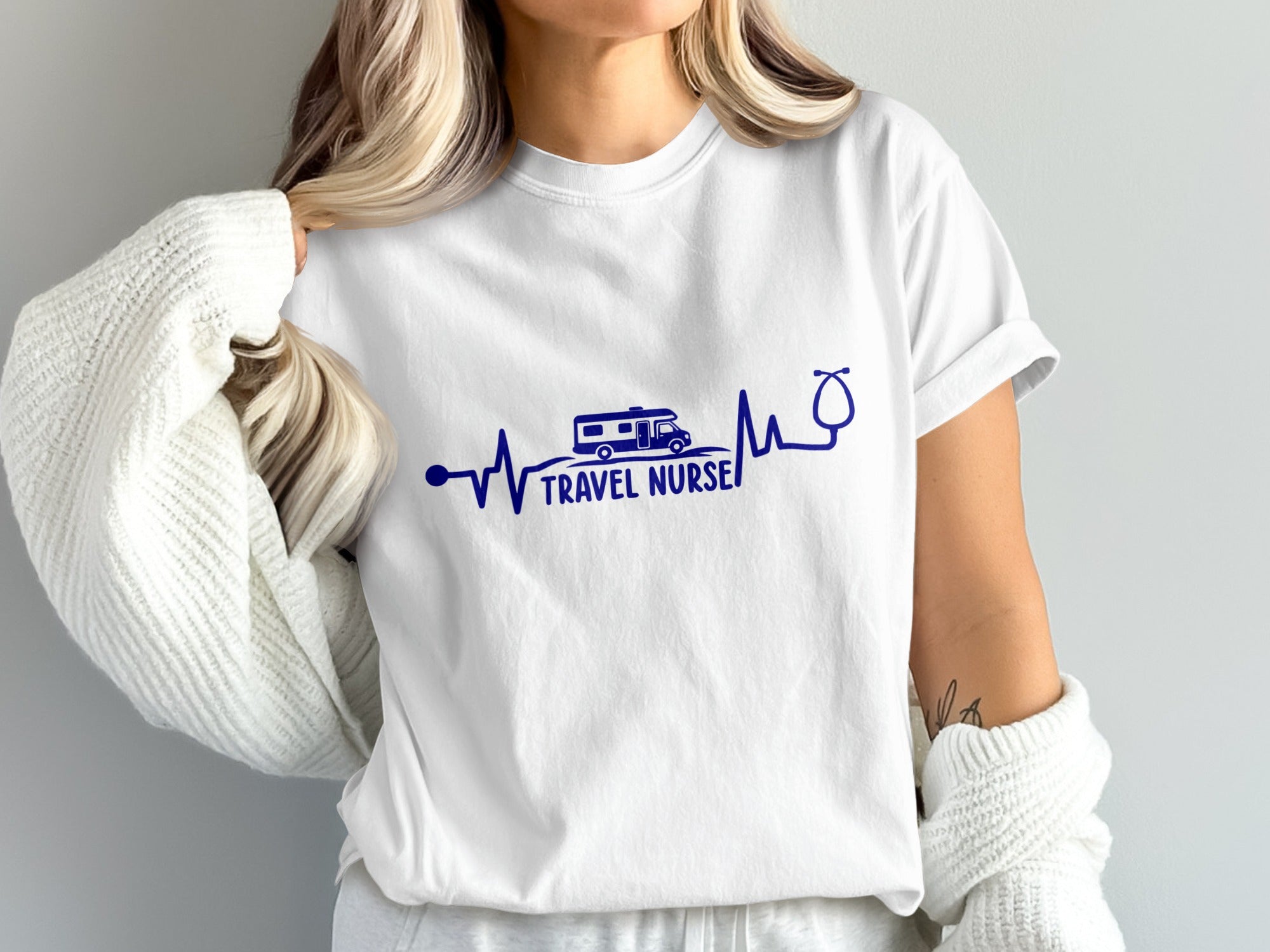 White t-shirt with a heartbeat line, camper van, and stethoscope forming "Travel Nurse".