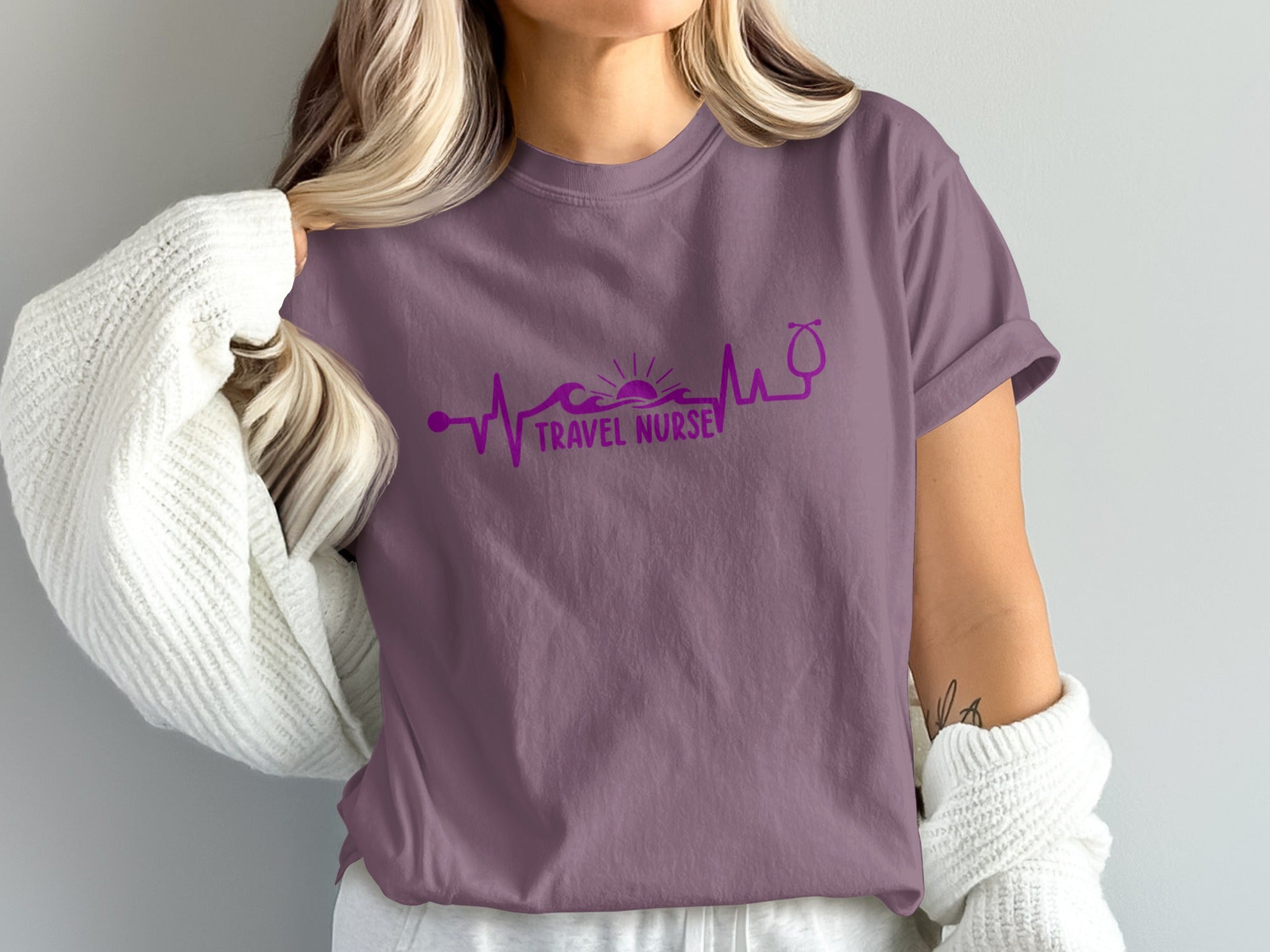Purple t-shirt with stethoscope and heartbeat line graphic.