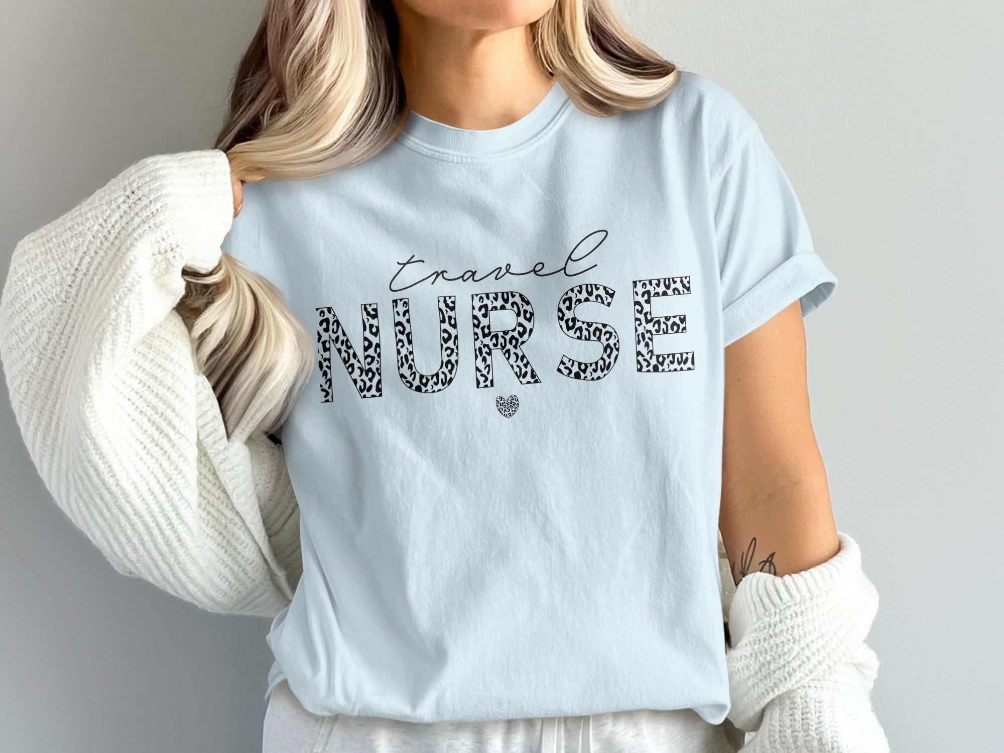 Light blue t-shirt with "travel NURSE" in leopard print and a small heart.