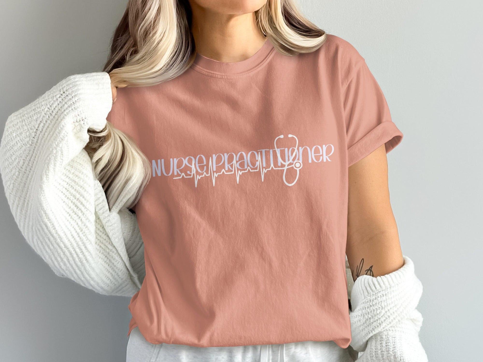 Peach t-shirt with white "nurse practitioner" text and a stethoscope ECG line.