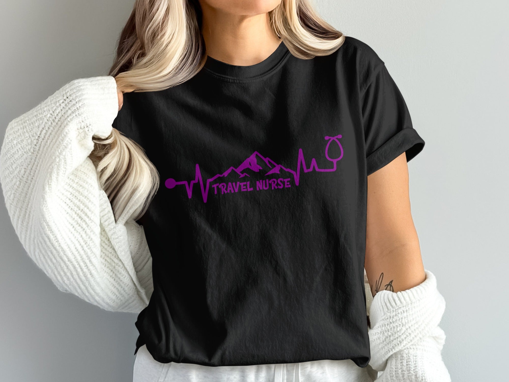 Black t-shirt with purple mountain and stethoscope heartbeat graphic and "TRAVEL NURSE" text.