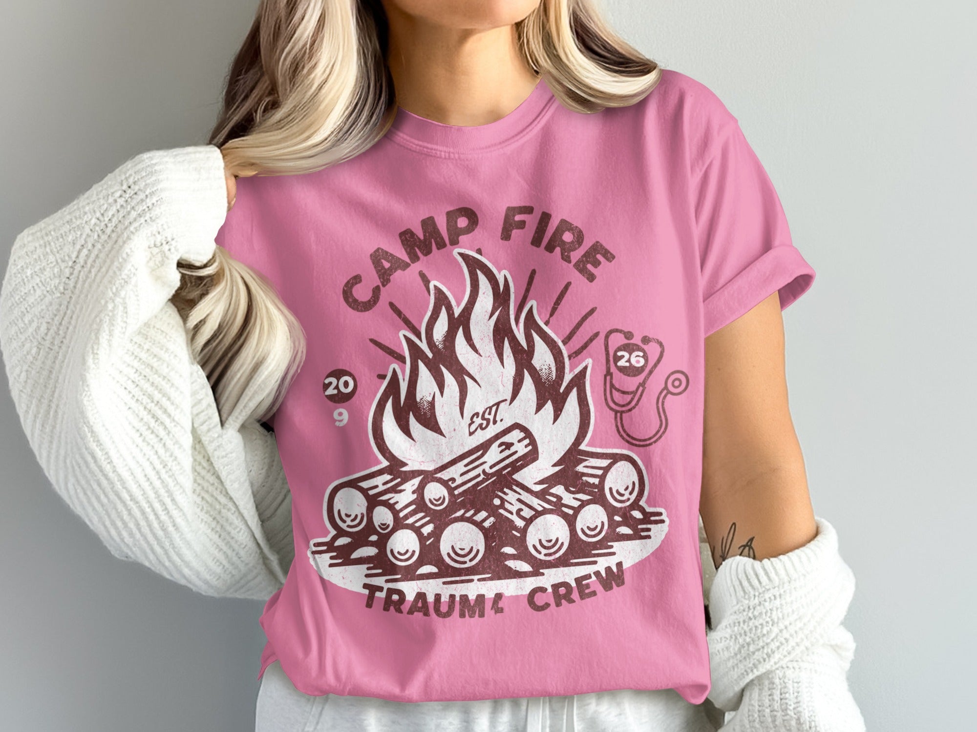 Pink t-shirt with campfire, logs, and "Camp Fire Trauma Crew" text.