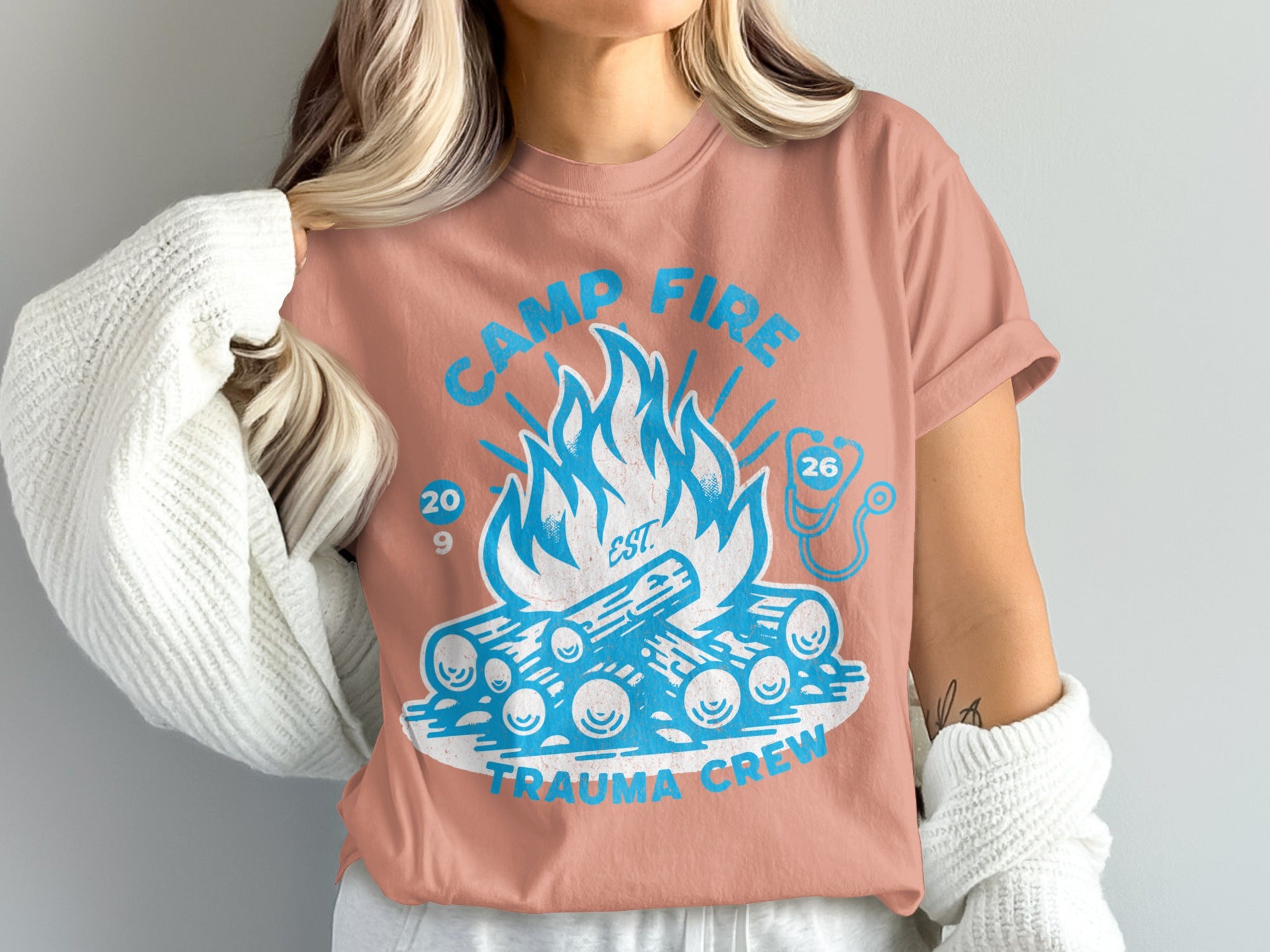 Salmon t-shirt with "Camp Fire Trauma Crew" text and campfire graphic.