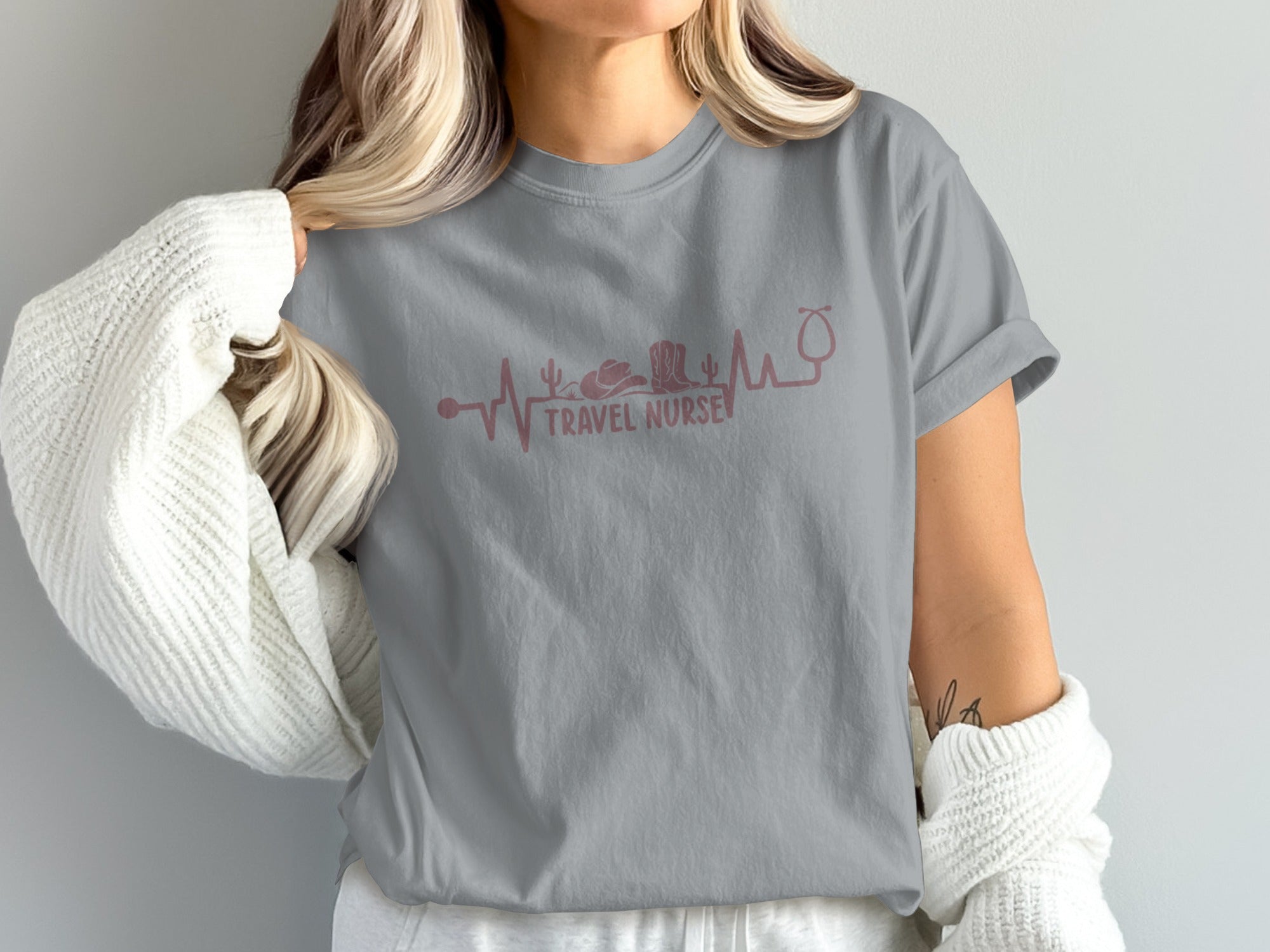 Gray t-shirt with pink heartbeat graphic featuring travel nurse stethoscope and cowboy hat.