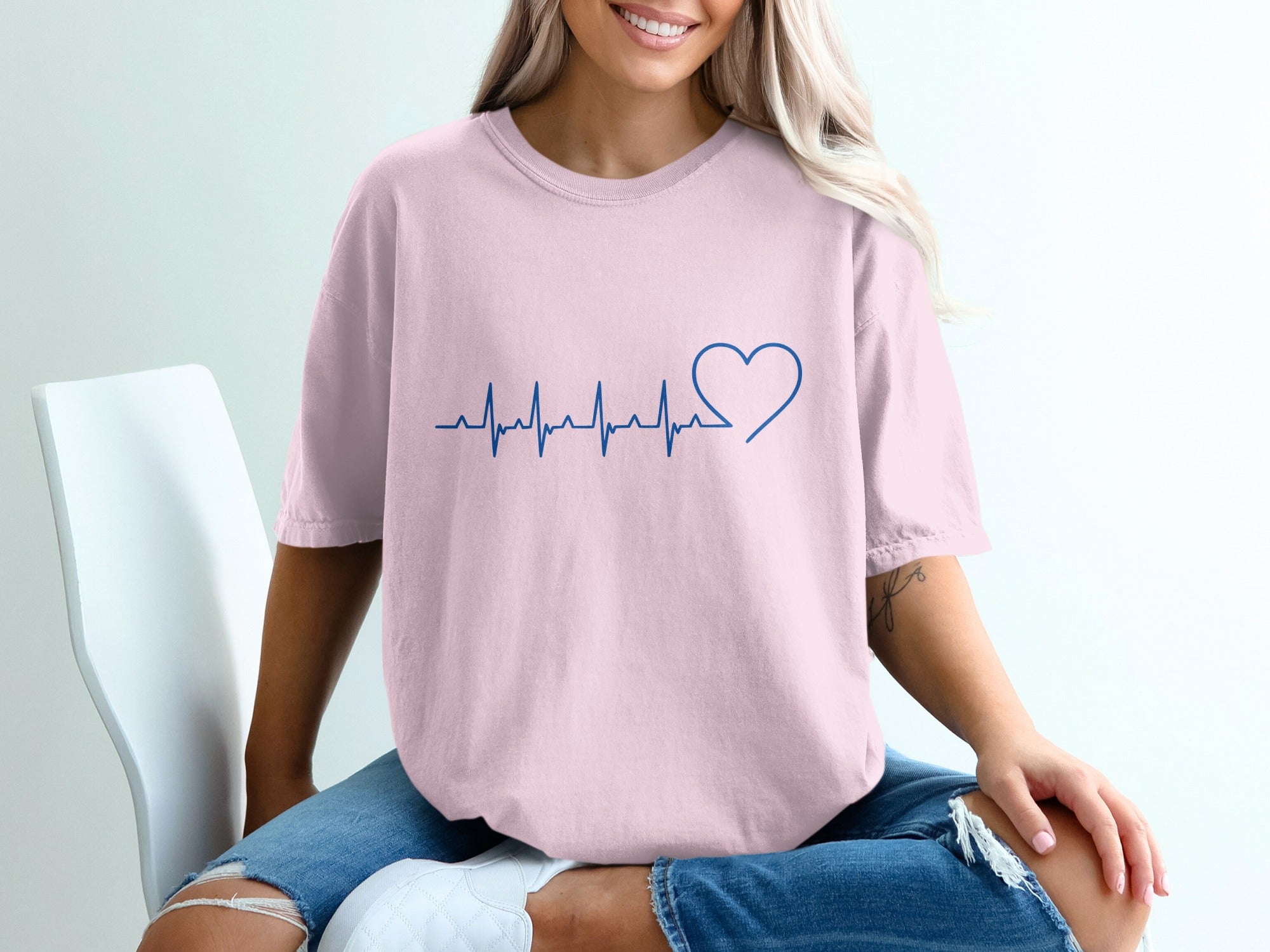 Pink t-shirt with a blue heartbeat and heart graphic.
