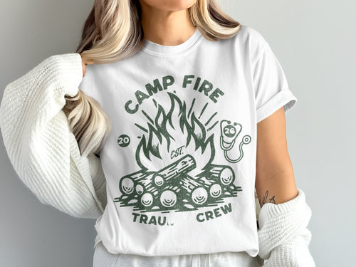 White t-shirt with green graphic of campfire and "Camp Fire Trauma Crew" text.