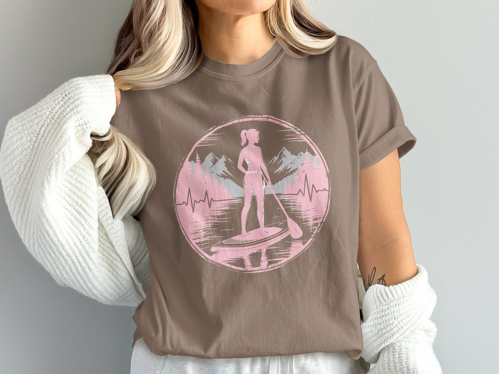 Woman on paddleboard with mountains, skyline, and heartbeat graphic.