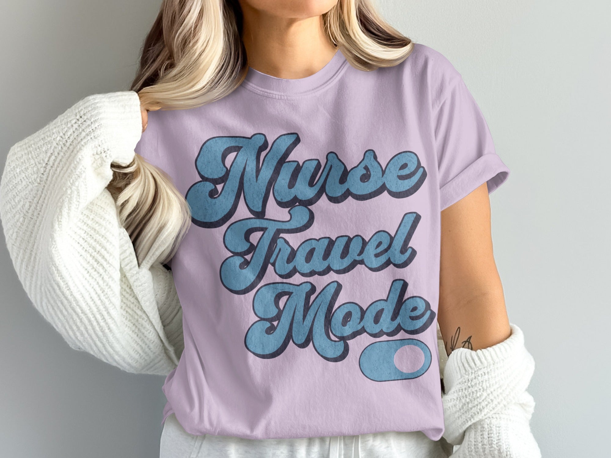 Purple t-shirt with "Nurse Travel Mode" in blue lettering.
