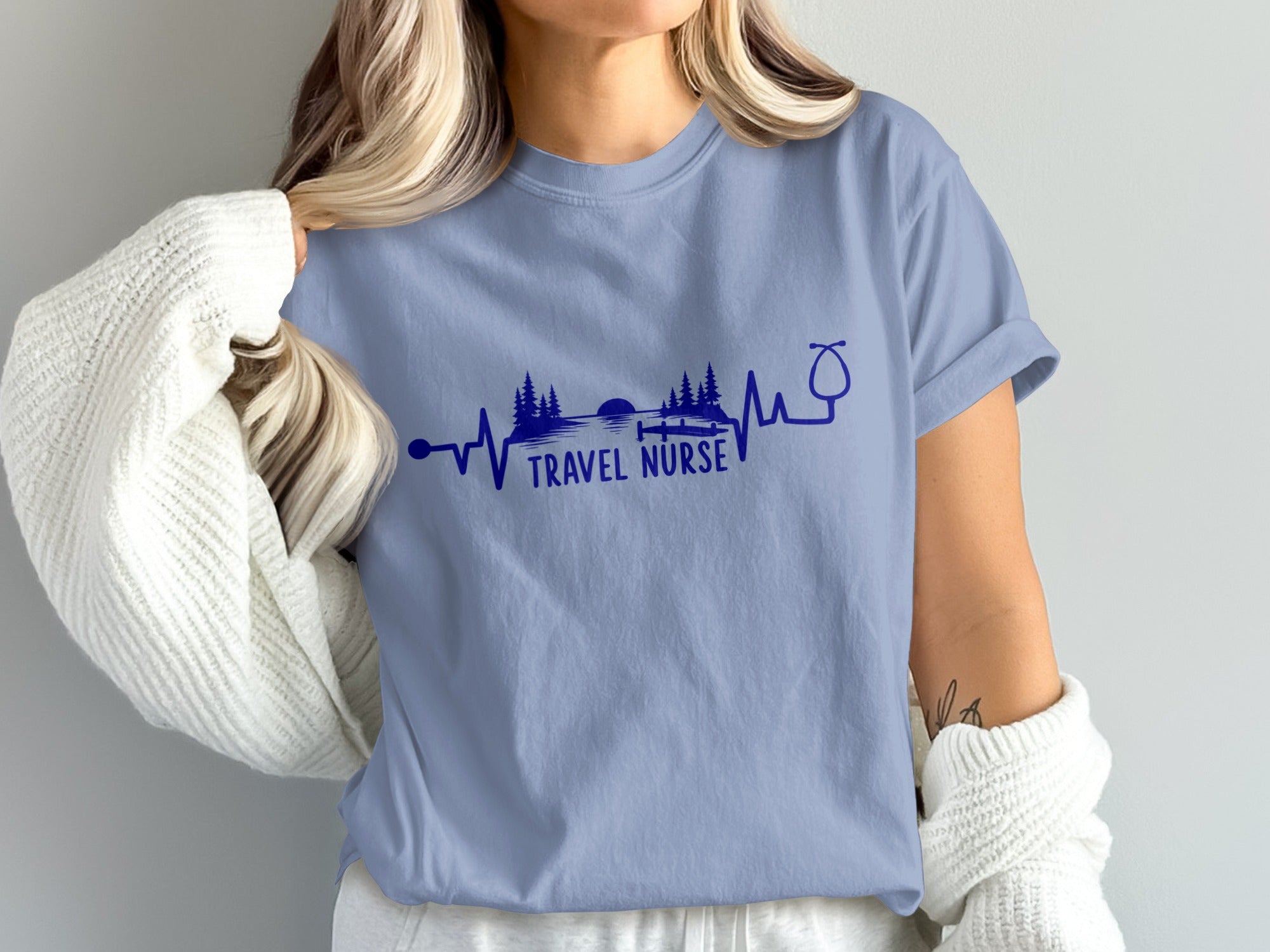 Blue t-shirt with "TRAVEL NURSE" text and a stethoscope heartbeat design.