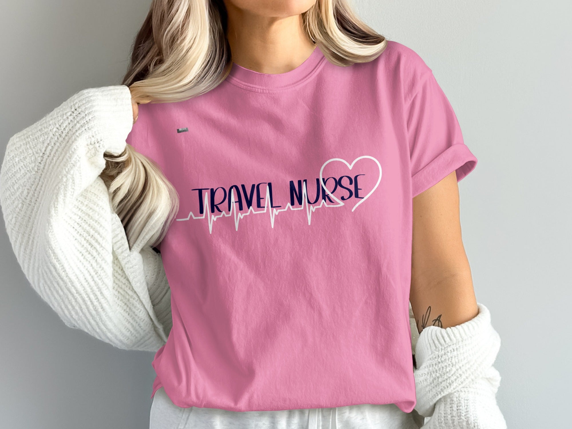 Pink t-shirt with "TRAVEL NURSE" in navy text and a white heartbeat graphic.
