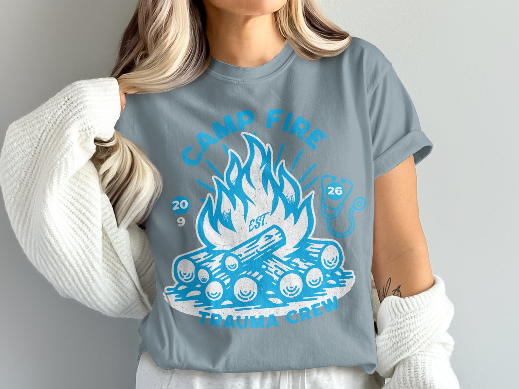 Camp fire trauma crew graphic on a light blue t-shirt.