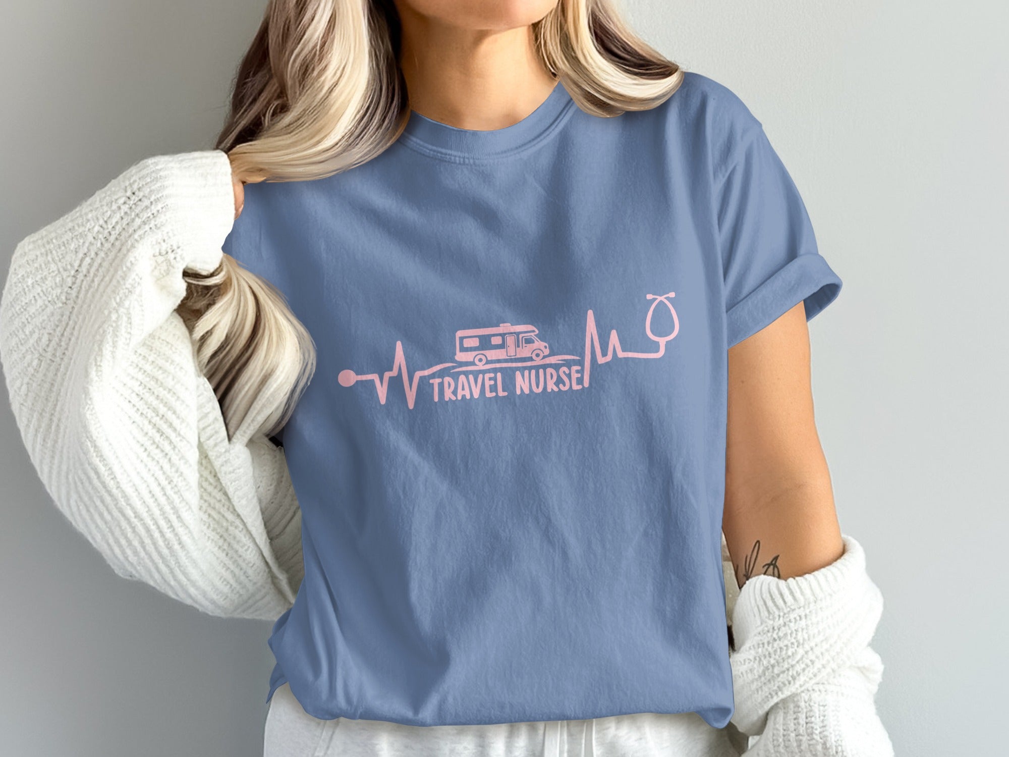 Blue t-shirt with pink RV and stethoscope electrocardiogram graphic and "TRAVEL NURSE" text.