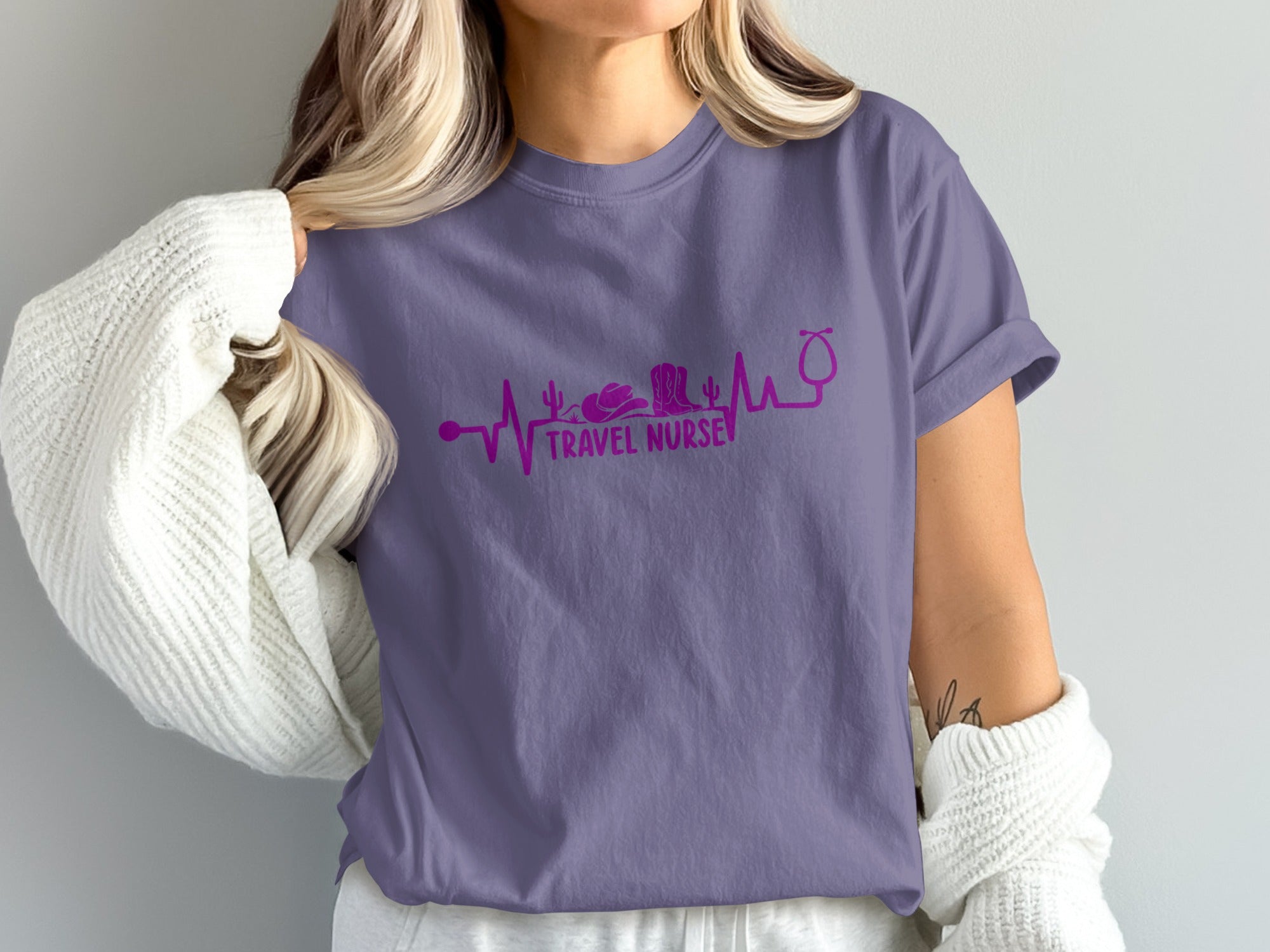 Purple t-shirt with stethoscope, cowboy boot, and heartbeat line.
