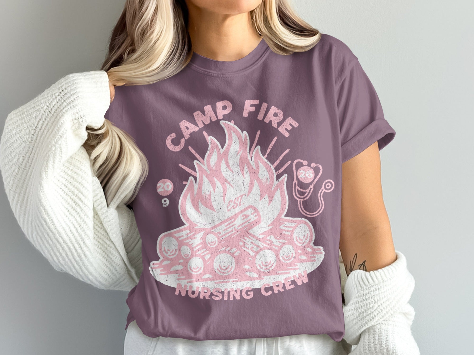 Camp Fire Nursing Crew graphic on a purple t-shirt.