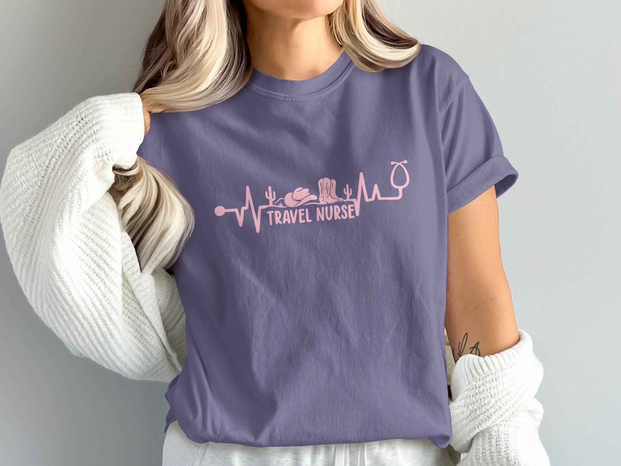 Purple t-shirt with heartbeat line featuring medical and travel icons.