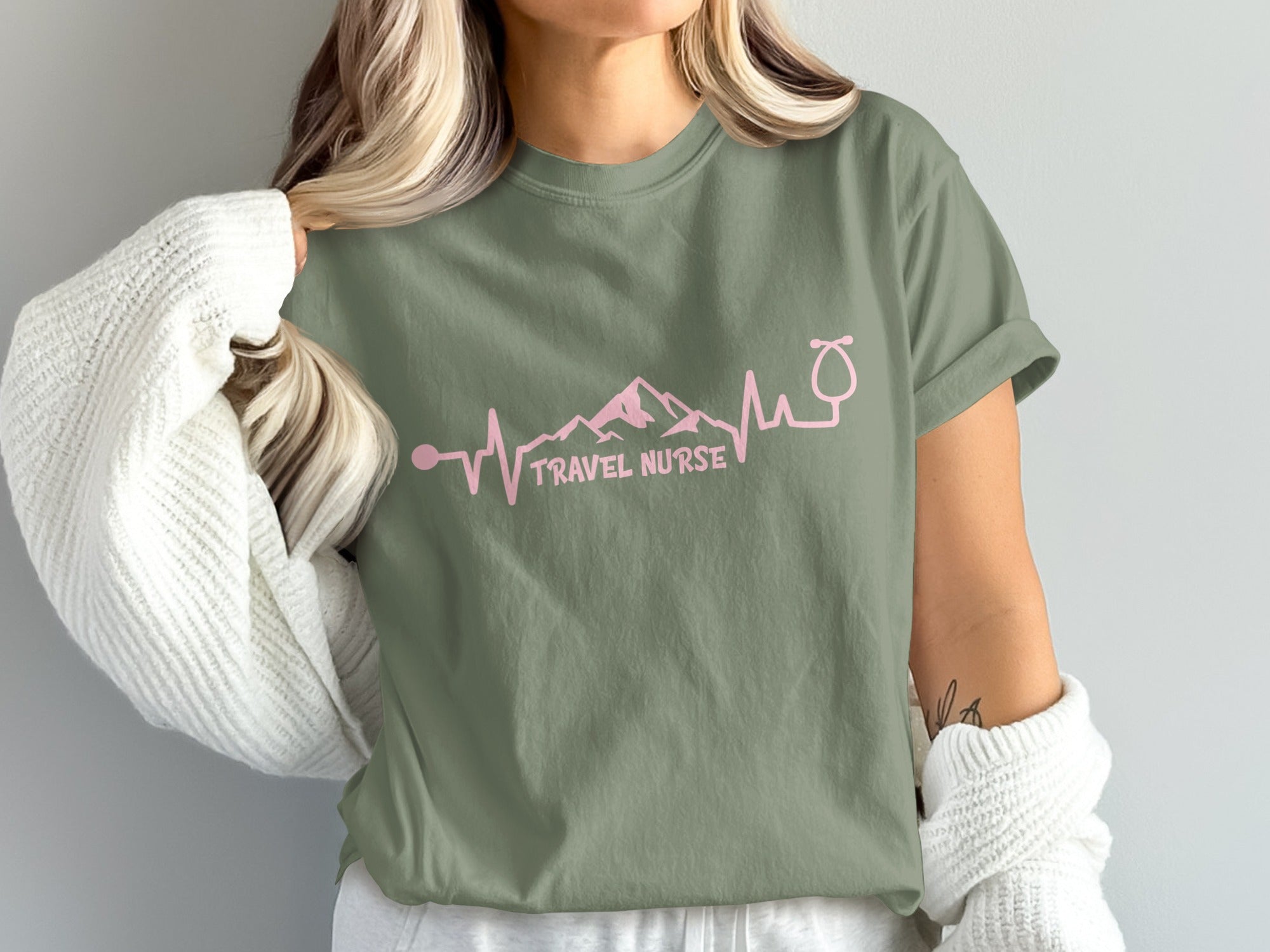 Olive green t-shirt with pink travel nurse heartbeat graphic and text.