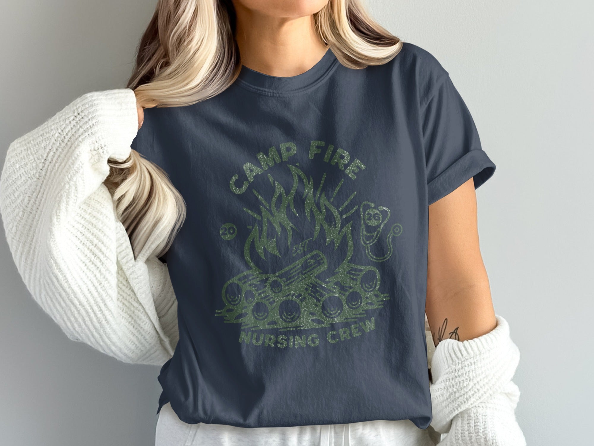 Dark blue t-shirt with green "Camp Fire Nursing Crew" text and campfire graphic.