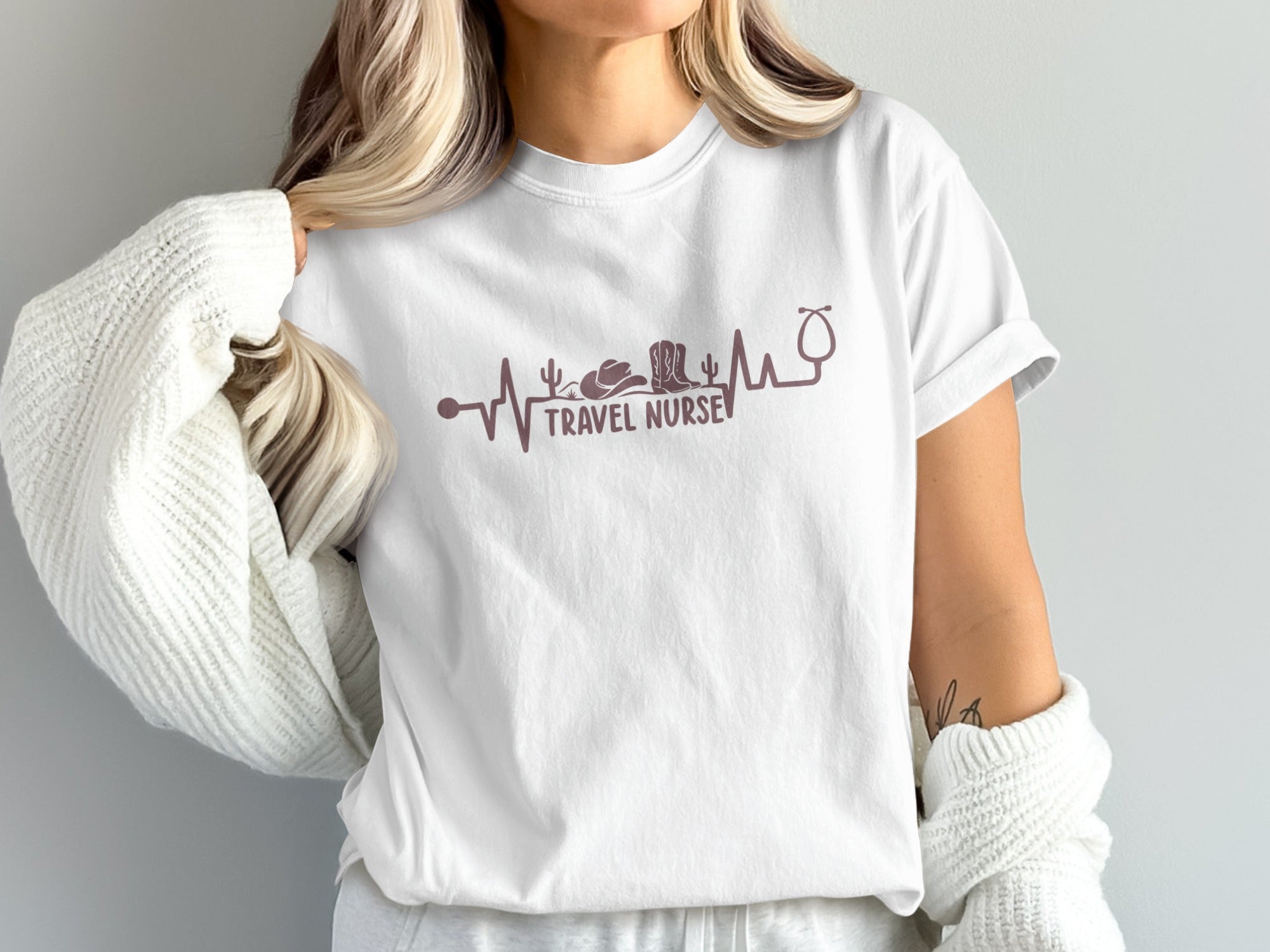 White t-shirt with purple travel nurse heartbeat graphic.
