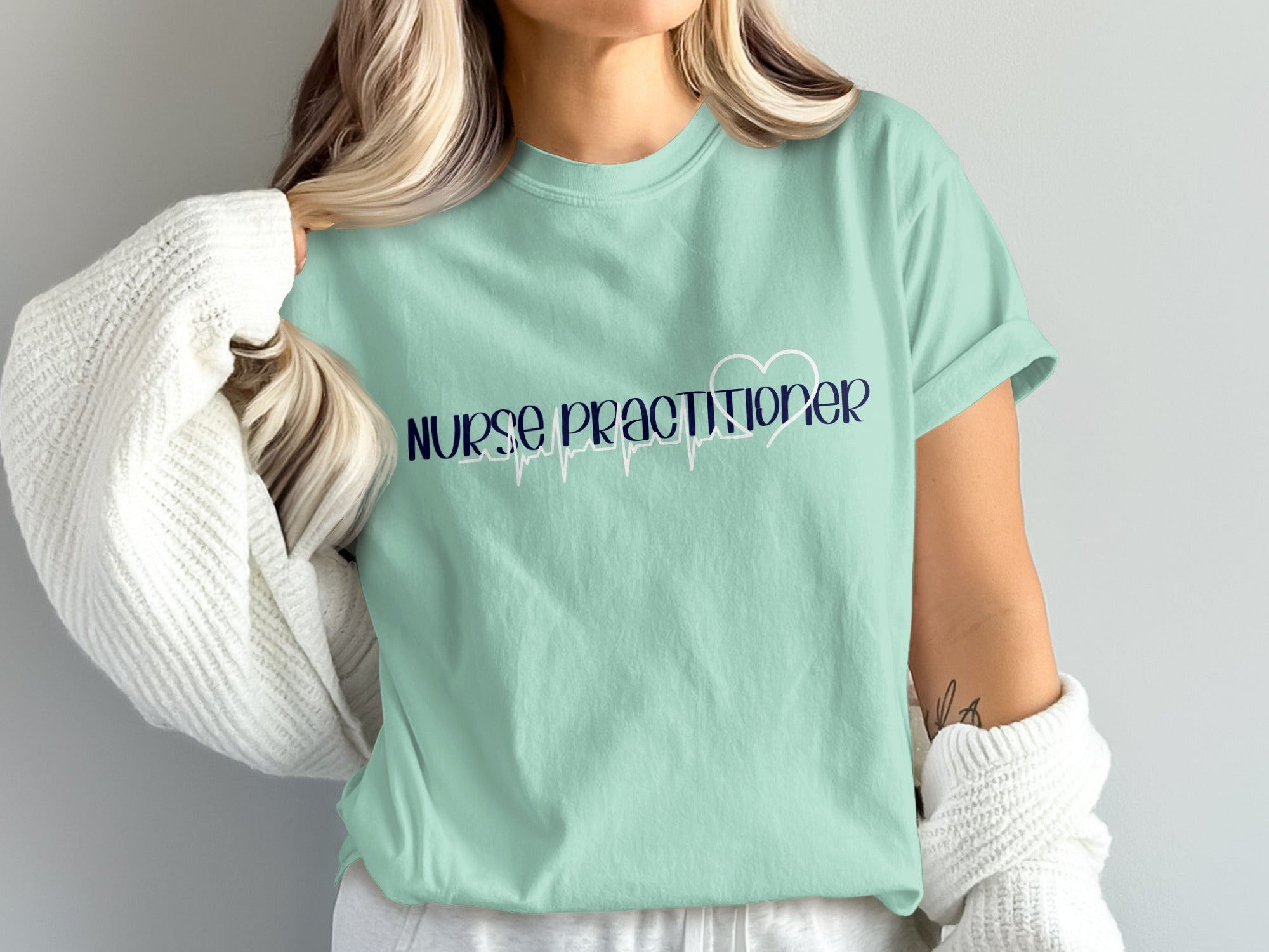 Light blue t-shirt with "Nurse Practitioner" text and a heart-shaped ECG line.