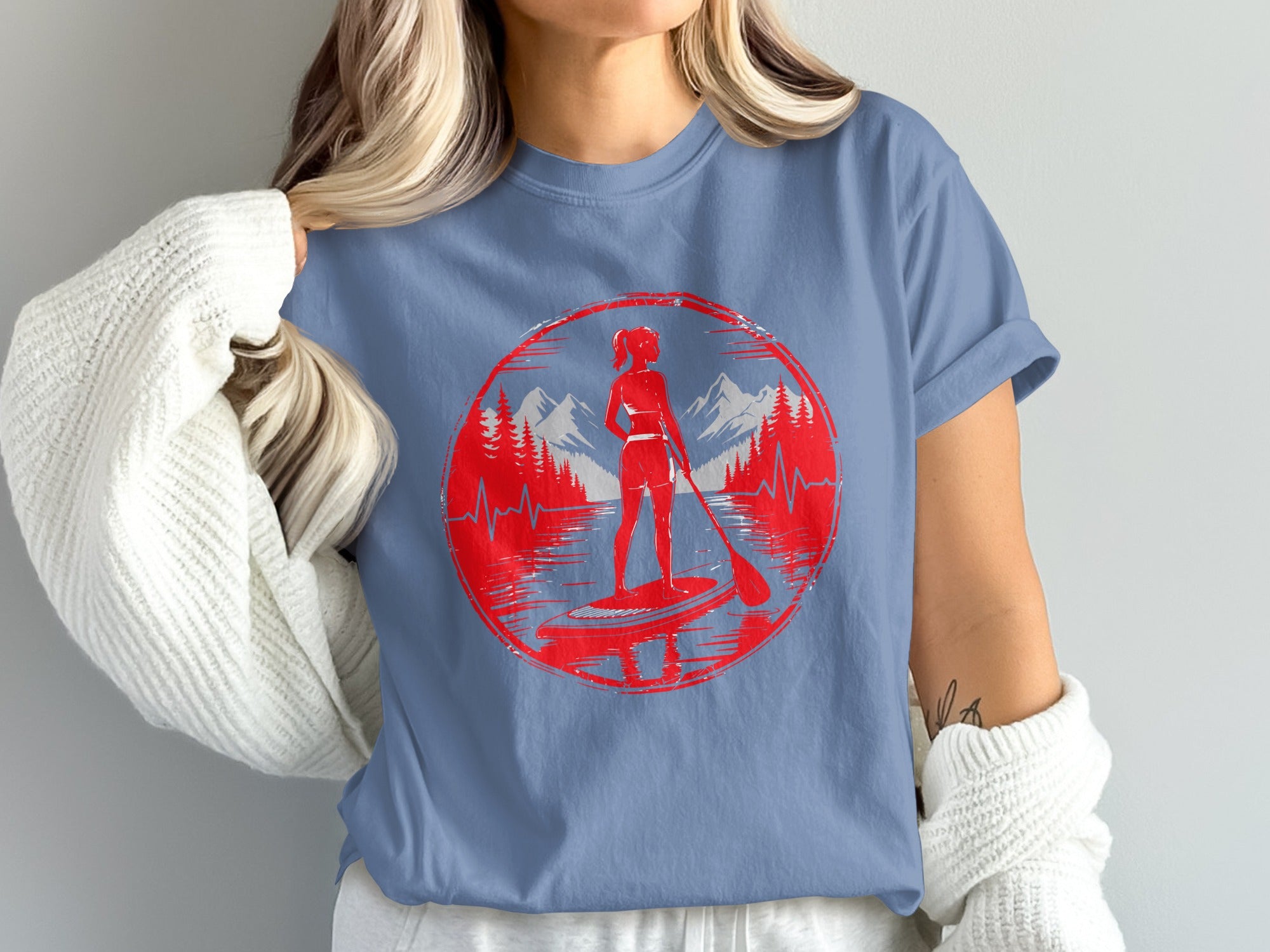 Red circular graphic of a woman paddleboarding with mountains and trees.
