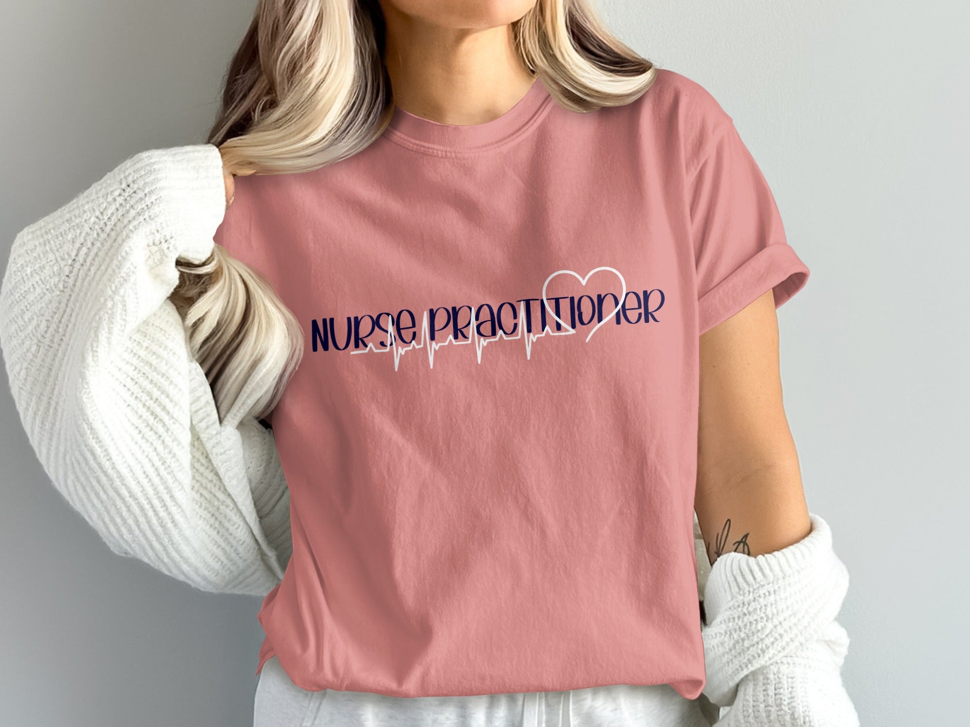 Pink t-shirt with "Nurse Practitioner" text and a heartbeat graphic.