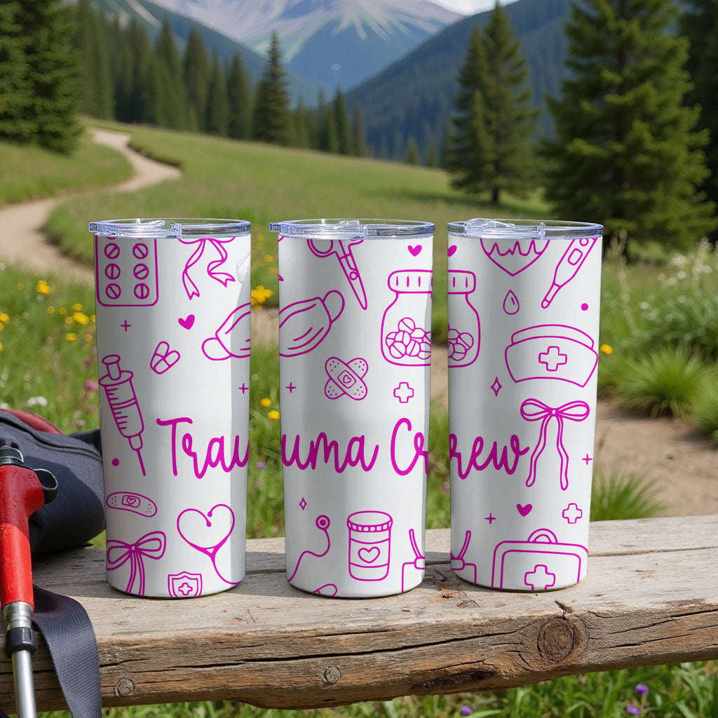 Three white tumblers with pink medical icons and "Trauma Crew" text.