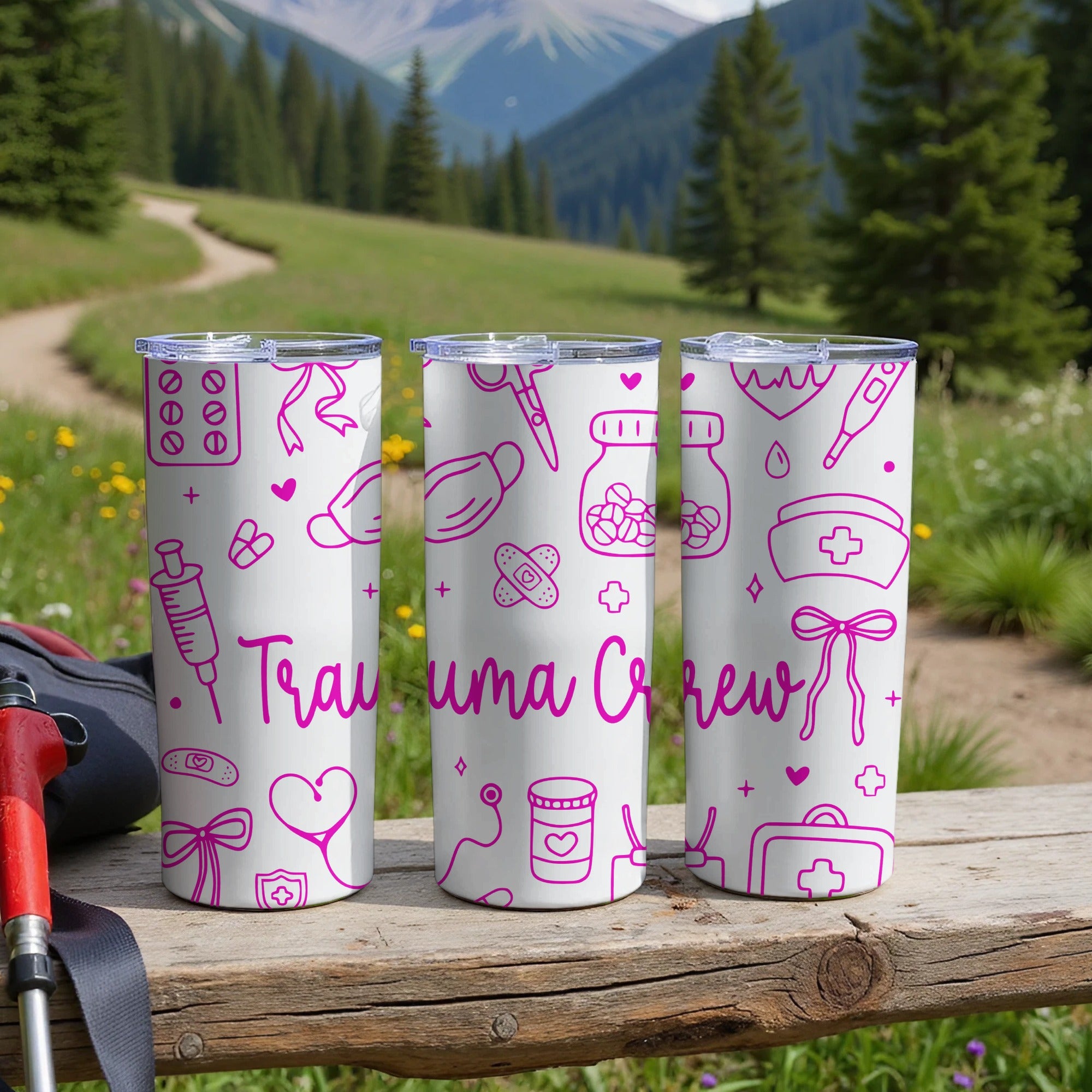 Three white tumblers with pink medical icons and "Trauma Crew" text.