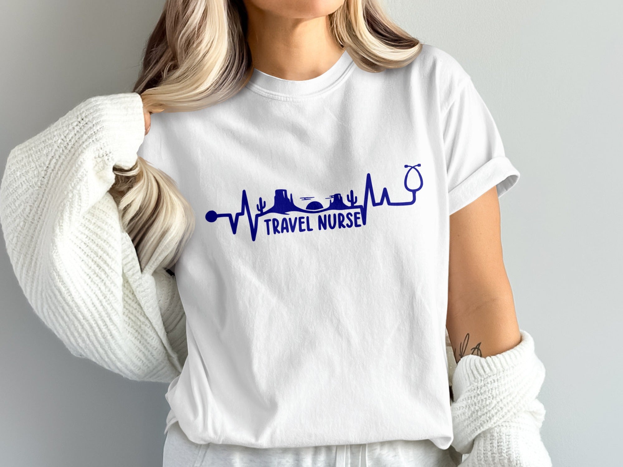 White t-shirt with blue "Travel Nurse" text and heartbeat line graphic.