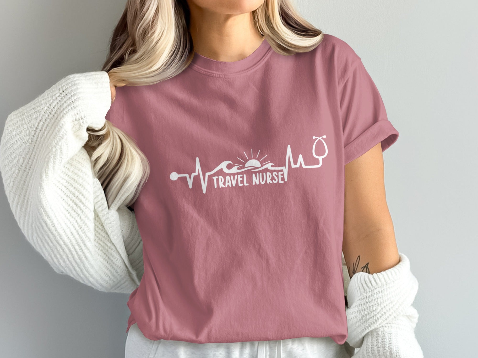 Pink t-shirt with "TRAVEL NURSE" and a heartbeat, sun, and stethoscope design.