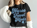 Black t-shirt with "Nurse Travel Mode" text in blue and purple gradient.
