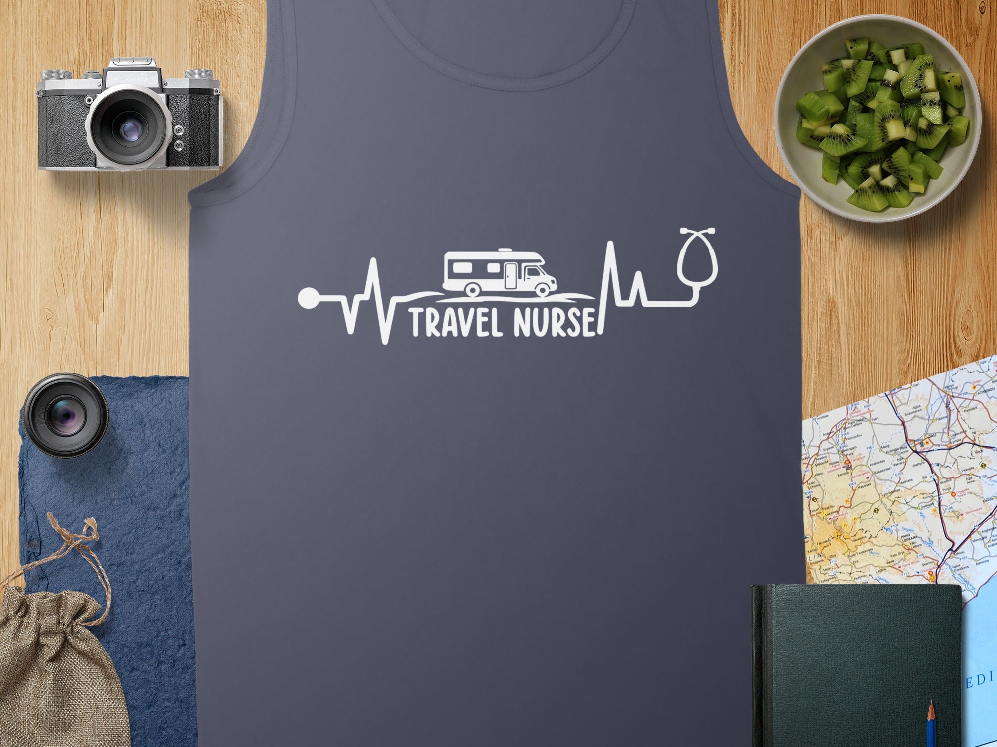 Travel Nurse heartbeat graphic on a dark gray tank top with camera and kiwi.