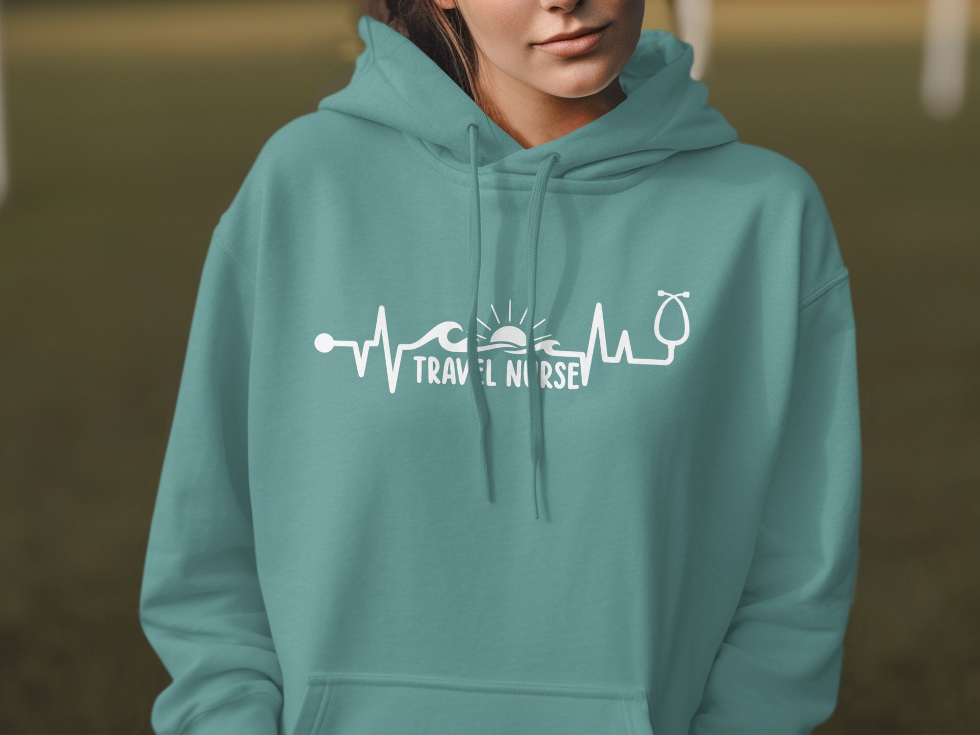 Teal hoodie with a white graphic of a heartbeat line, waves, sun, and stethoscope with "Travel Nurse" text.