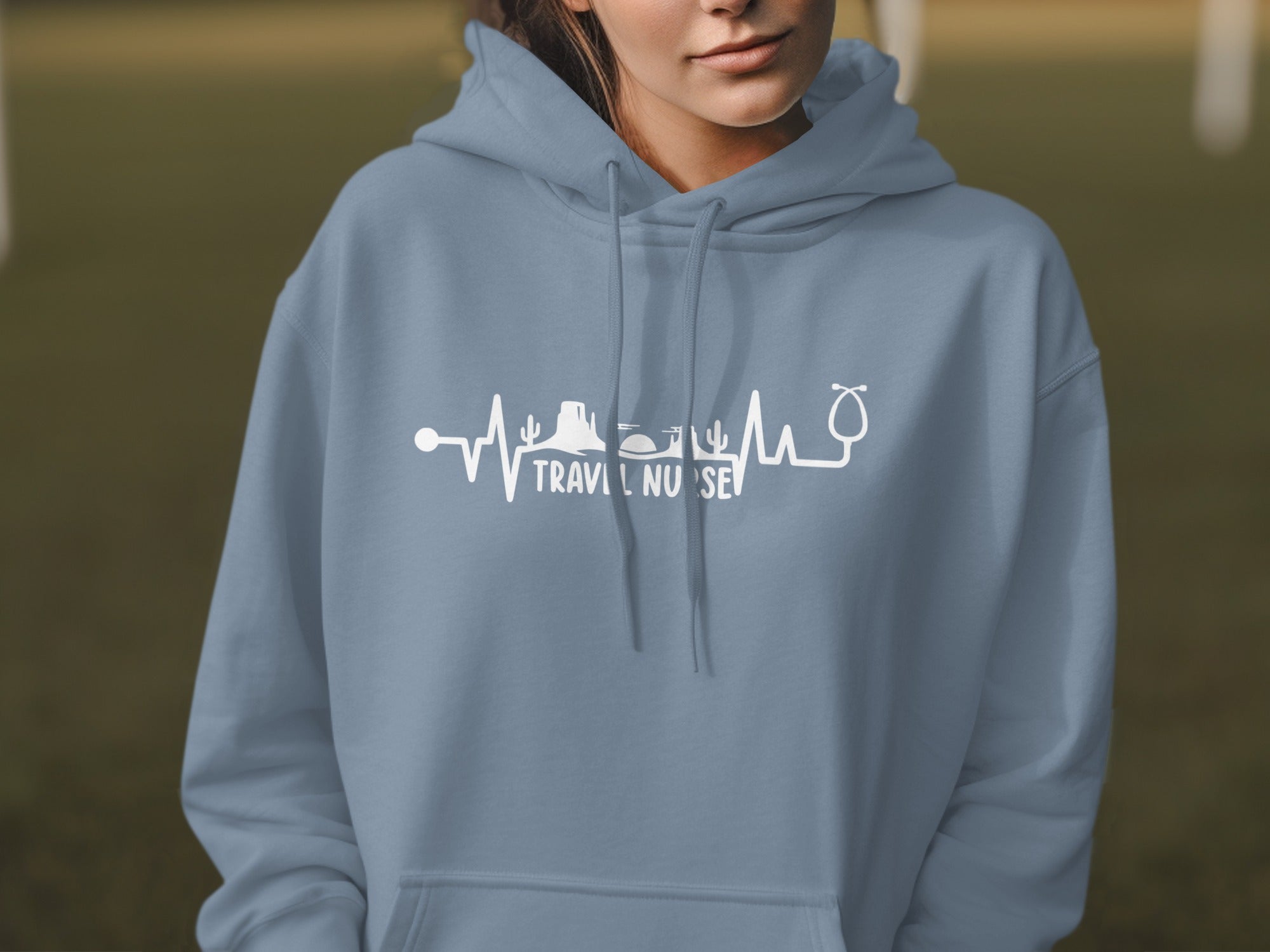 Blue hoodie with "TRAVEL NURSE" text and stethoscope heart rhythm graphic.