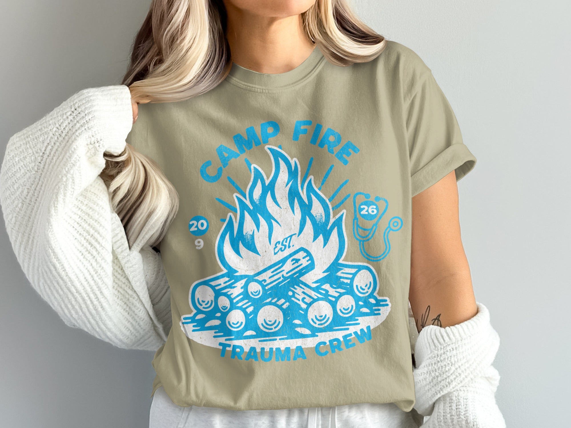 Camp Fire Trauma Crew 26' design on a light tan t-shirt.