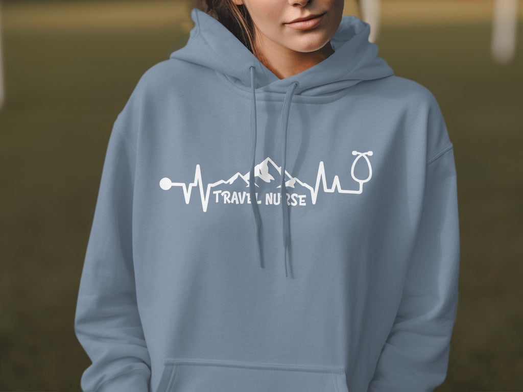 Light blue hoodie with "Travel Nurse" text and mountain/stethoscope design.