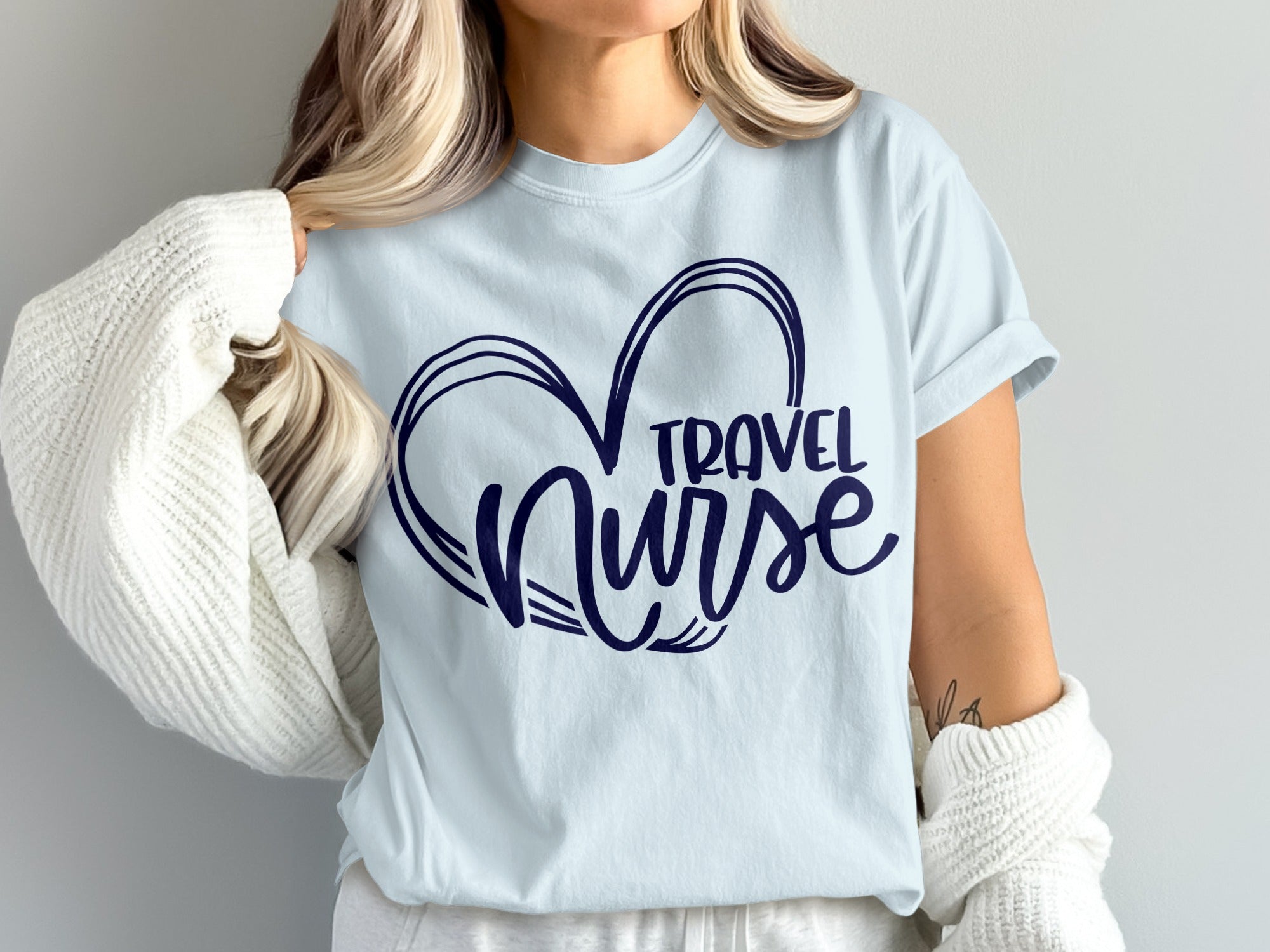 Light blue t-shirt with navy blue heart and "TRAVEL NURSE" text.