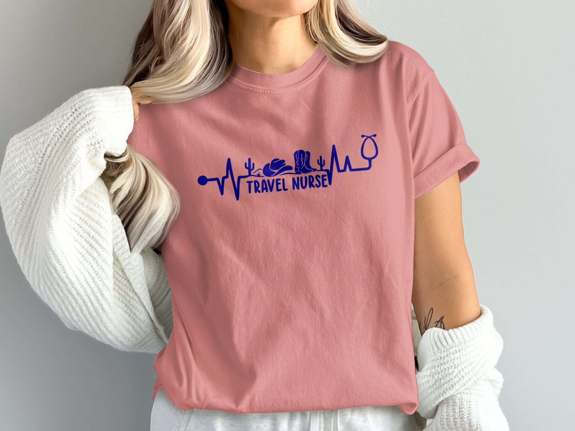 Pink t-shirt with blue heartbeat graphic, cowboy boot, cactus, and stethoscope, reading "TRAVEL NURSE".