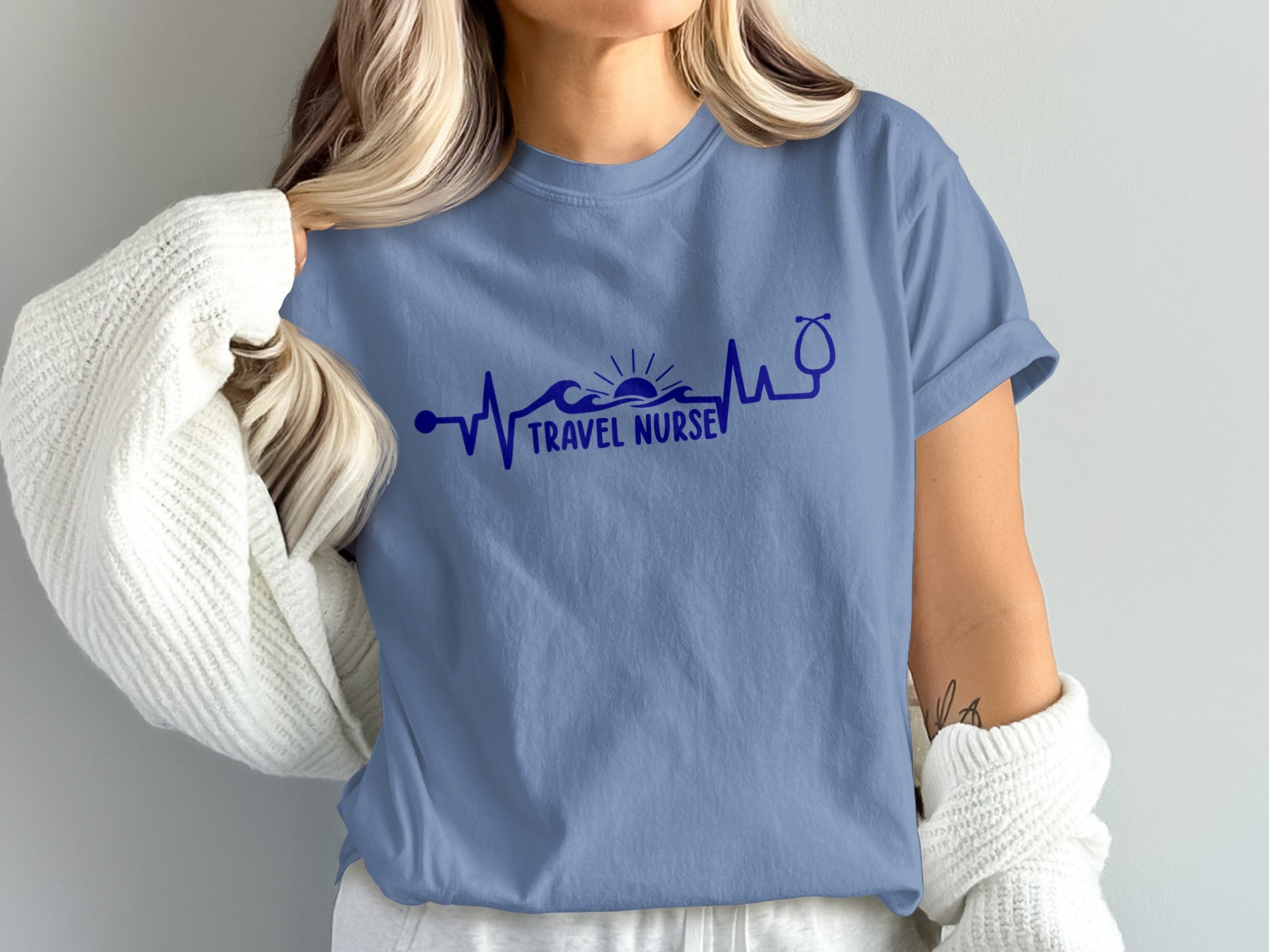 Blue t-shirt with "Travel Nurse" text, sun, waves, and stethoscope design.