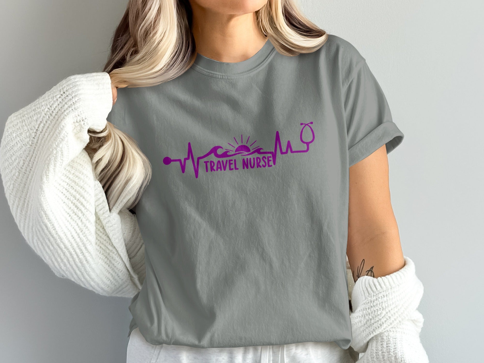 T-shirt with purple stethoscope and heartbeat line graphic on grey background.