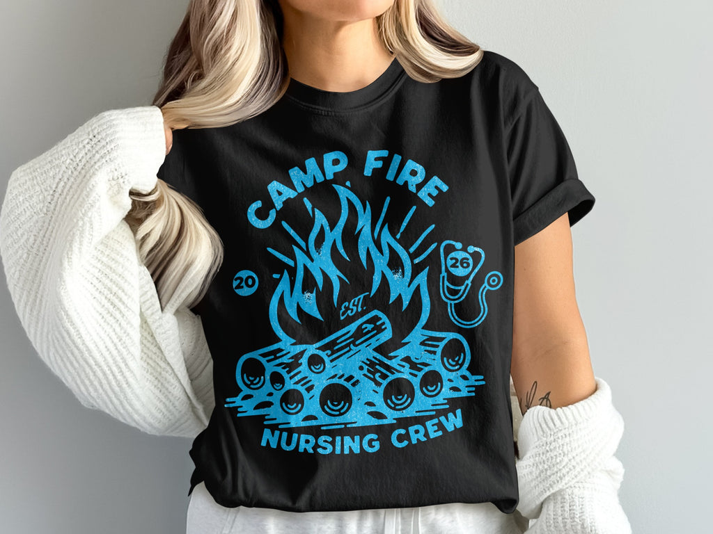 Black t-shirt with blue campfire, logs, and stethoscope graphic, "CAMP FIRE NURSING CREW" text.