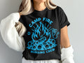Black t-shirt with blue campfire, logs, and stethoscope graphic, "CAMP FIRE NURSING CREW" text.