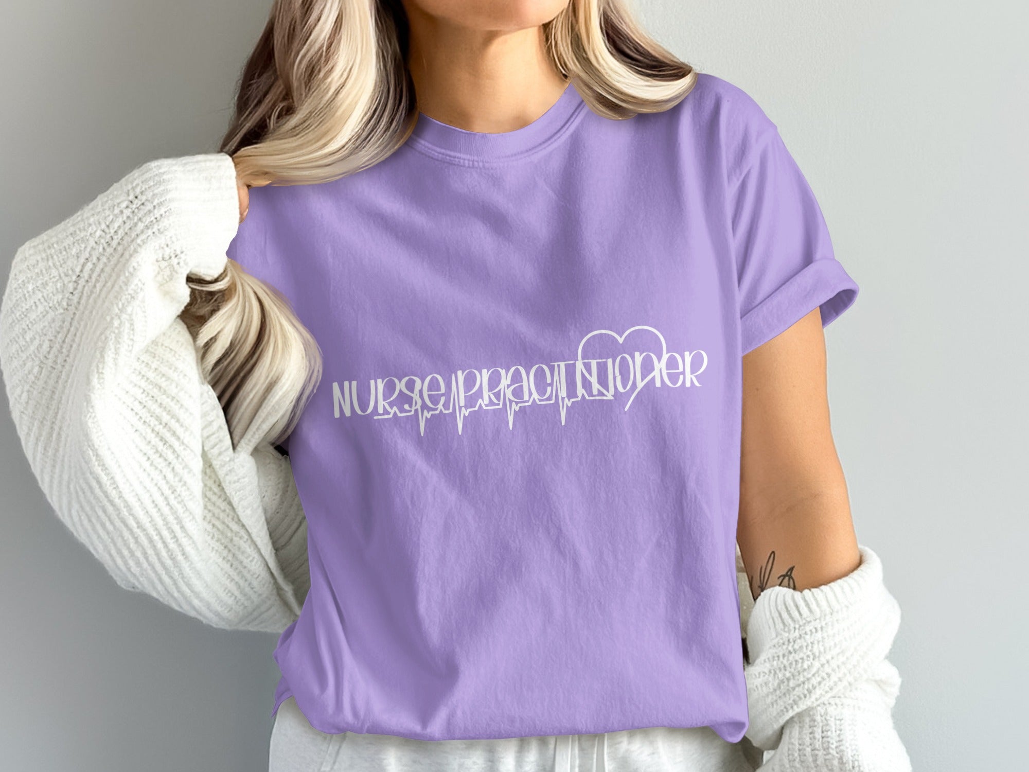 Purple t-shirt with white "Nurse Practitioner" text and heartbeat line graphic.