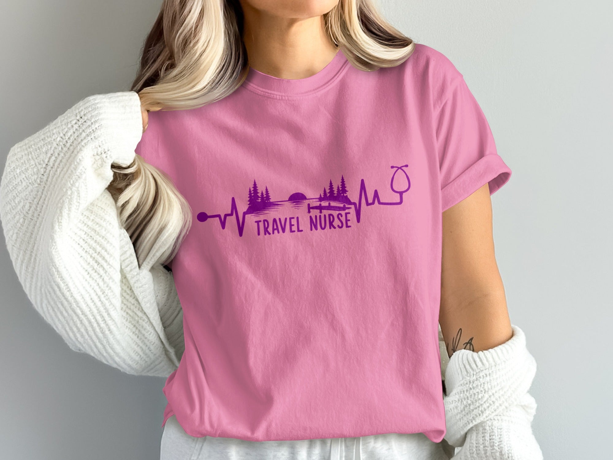 Pink t-shirt with "Travel Nurse" text and heartbeat, stethoscope, and nature graphic.