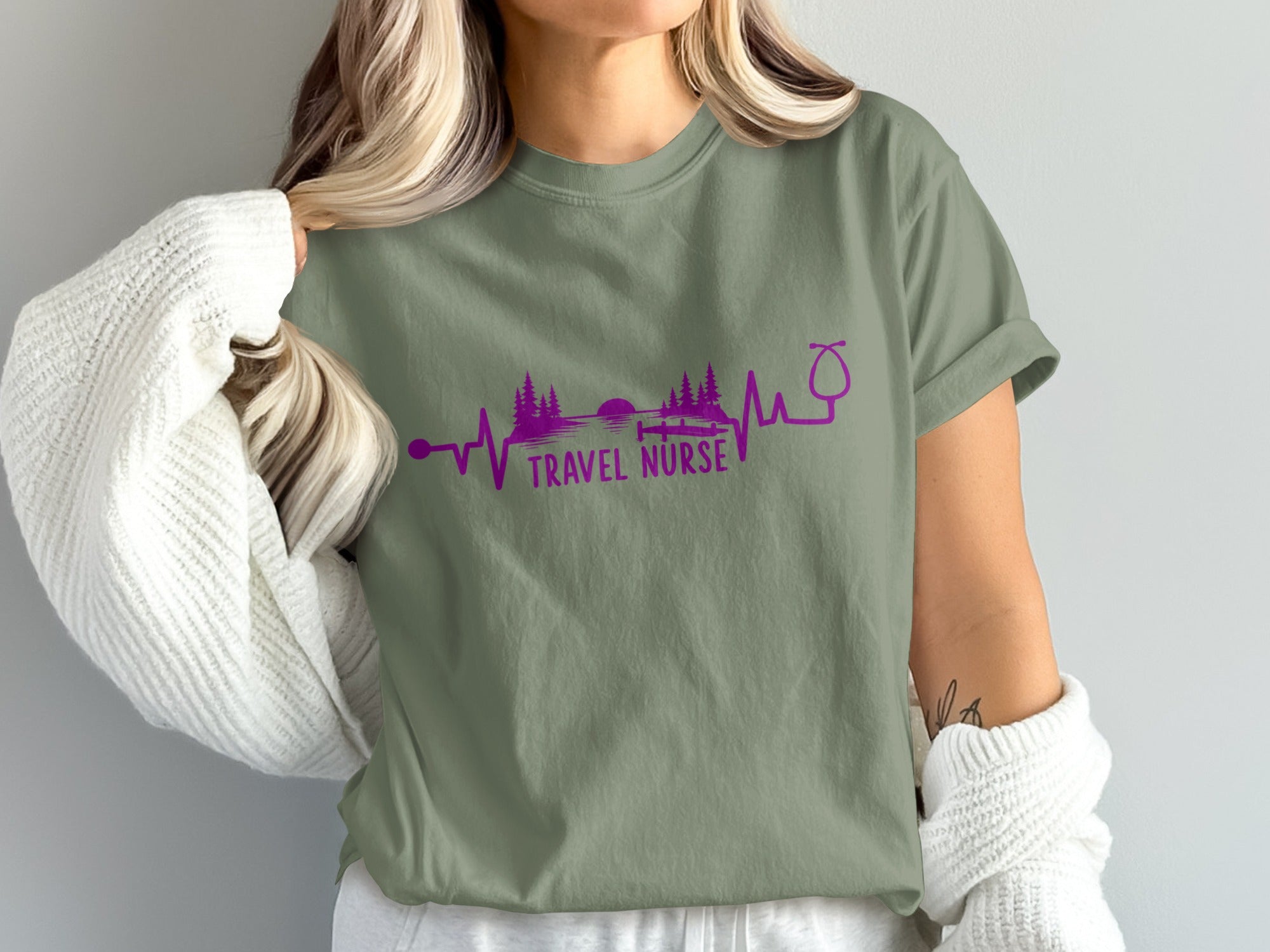Olive green t-shirt with purple heartbeat graphic and "TRAVEL NURSE" text.