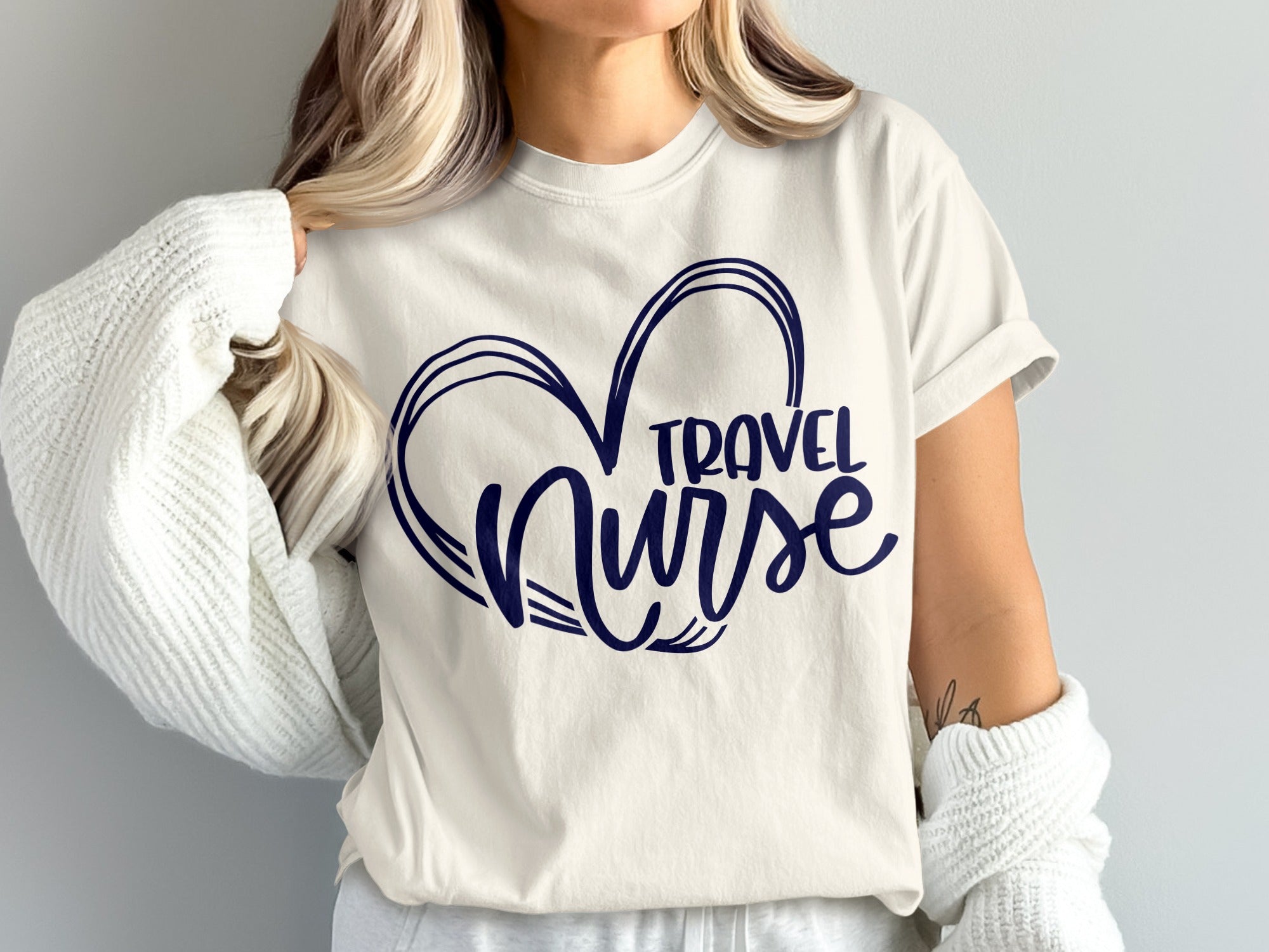 White t-shirt with navy blue "Travel Nurse" text inside a heart shape.