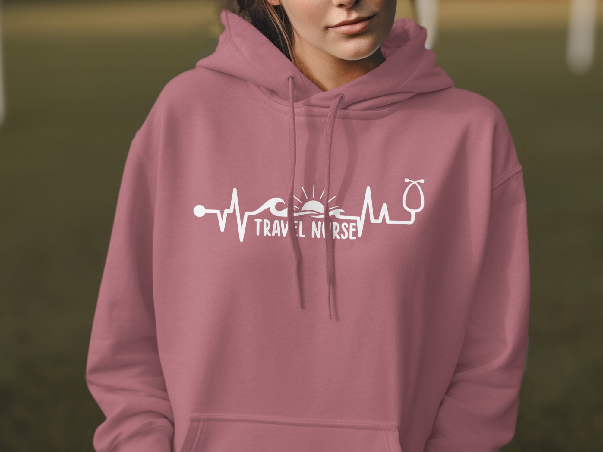 Pink hoodie with "Travel Nurse" text and a heartbeat graphic.